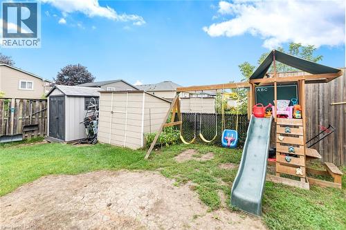 Expansive backyard featuring a partial grass lawn, two storage sheds, and a wooden fence - 42 Saturn Road, Port Colborne, ON 