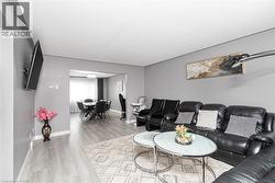 Wood-finish flooring throughout, with a framed opening leading to a dining area - 