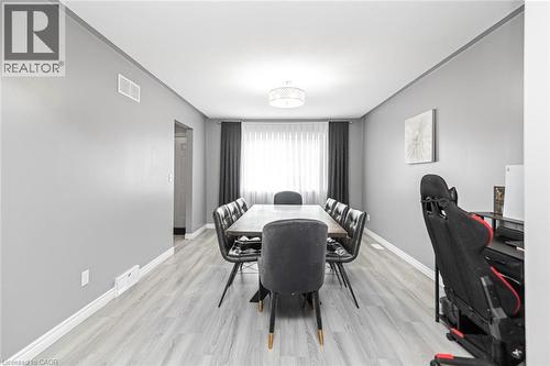 Recessed lighting and a decorative ceiling fixture illuminate this space, featuring wood-finish flooring and light gray painted walls - 42 Saturn Road, Port Colborne, ON 