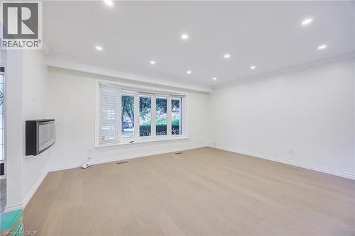 Recessed lighting, crown molding, wood-finish flooring, bay window with shutters, and a wall-mounted electronic fireplace - 3148 Terraview Court, Burlington, ON 