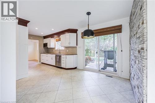 Bright kitchen featuring white cabinetry, stainless steel appliances, and a tiled backsplash - 3148 Terraview Court, Burlington, ON 