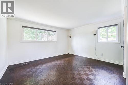 Parquet wood-finish flooring, crisp white walls, crown molding, and multiple windows with roller shades - 3148 Terraview Court, Burlington, ON 