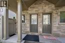 Stone veneer facade, covered porch with pillars, two entry doors with glass inserts, exterior wall sconces, and a side gate - 931 Glasgow Street Unit# 27B, Kitchener, ON 