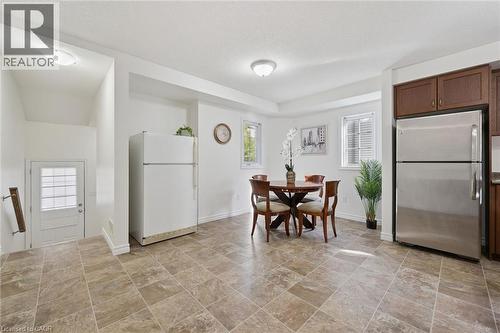 Tiled flooring, stainless steel refrigerator, dark wood-finish cabinetry, multiple windows, and recessed lighting - 931 Glasgow Street Unit# 27B, Kitchener, ON 