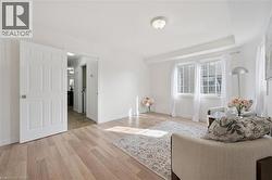 Recessed ceiling light, two large windows, wood-finish flooring, and white paneled doors - 