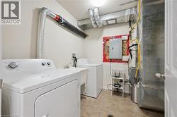 Utility area featuring a laundry sink, electrical panel, and tiled flooring - 