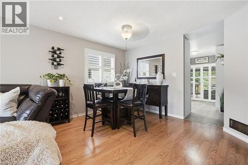 Hardwood-finish flooring, neutral wall paint, and white plantation shutters - 94 Kent Road, Brantford, ON 