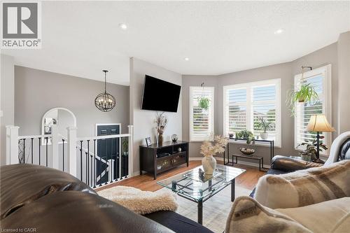 Hardwood-finish flooring, recessed lighting, bay windows with plantation shutters, an open-concept railing, and an arched entryway - 94 Kent Road, Brantford, ON 