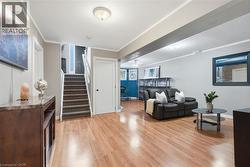 Wood-finish flooring, recessed lighting, white interior doors, and a carpeted staircase - 