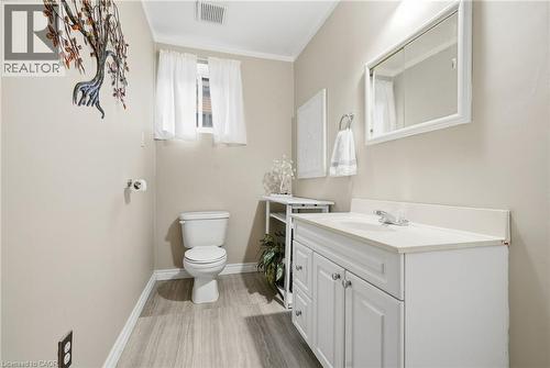 White vanity with dual cabinet doors and an integrated sink - 94 Kent Road, Brantford, ON 