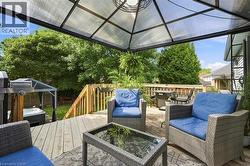 Expansive wood-finish deck with a transparent panel gazebo and built-in hot tub - 