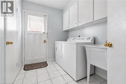 White tile flooring, utility sink, white upper cabinetry, and white appliances - 152 Hilda Avenue, North York, ON 