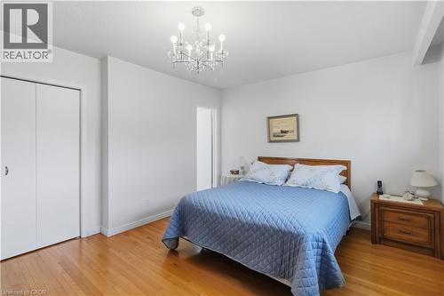 Polished wood-finish flooring, white walls, bi-fold closet doors, and a crystal chandelier - 152 Hilda Avenue, North York, ON 