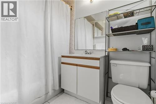 White vanity with wood-finish trim, a single basin sink, and a framed mirror - 152 Hilda Avenue, North York, ON 