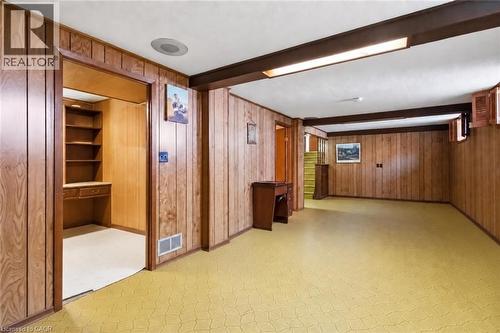 Spacious room featuring wood paneling, recessed lighting, exposed ceiling beams, and a built-in desk with shelving - 152 Hilda Avenue, North York, ON 