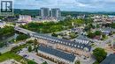Aerial perspective showcasing urban residential buildings, proximity to a river, and surrounding green spaces - 25 Concession Street Unit# 110, Cambridge, ON 