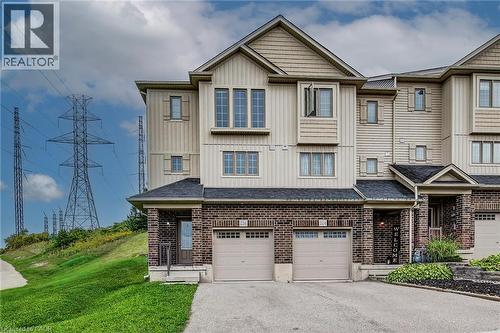 Multi-level townhouse exterior featuring brick and siding facade, covered front entry, and attached garage - 226 Maitland Street, Kitchener, ON 
