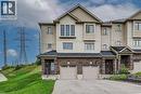 Multi-level townhouse exterior featuring brick and siding facade, covered front entry, and attached garage - 226 Maitland Street, Kitchener, ON 