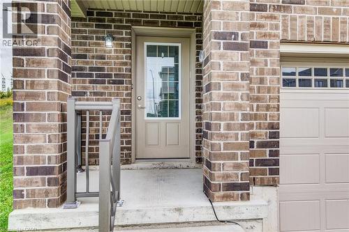 Brick exterior with a concrete front entry, modern metal handrail, and an attached garage with panel detailing - 226 Maitland Street, Kitchener, ON 