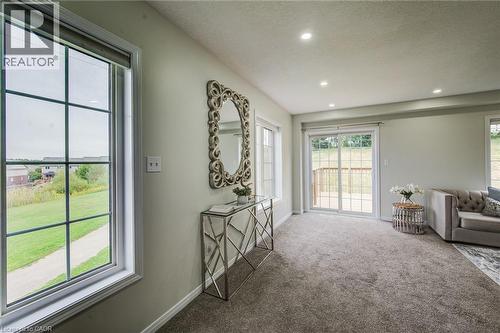 Spacious room featuring neutral carpeting, recessed lighting, and a sliding glass door opening to an outdoor deck - 226 Maitland Street, Kitchener, ON 