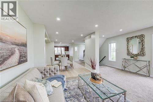 Recessed lighting throughout, wood-finish flooring, staircase with dark wood handrail, and white trim windows - 226 Maitland Street, Kitchener, ON 