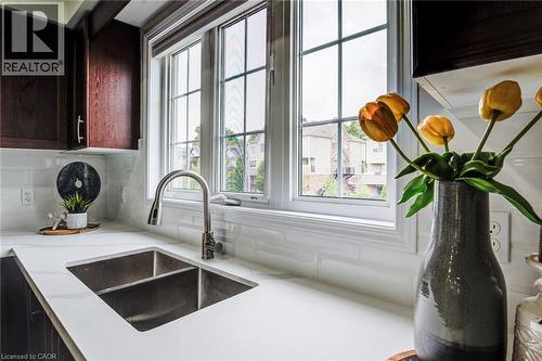 White countertop with an integrated stainless steel double sink and gooseneck faucet - 226 Maitland Street, Kitchener, ON 