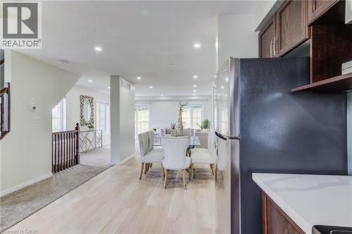 Recessed lighting, wood-finish flooring, white walls, dark wood-finish cabinetry, and stainless-steel refrigerator - 226 Maitland Street, Kitchener, ON 