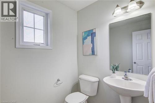 Pedestal sink, wall-mounted rectangular mirror, and two-light vanity fixture - 226 Maitland Street, Kitchener, ON 
