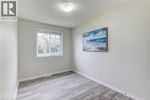 Light gray wall paint, wood-finish flooring, white window trim, and a flush mount ceiling light - 226 Maitland Street, Kitchener, ON 