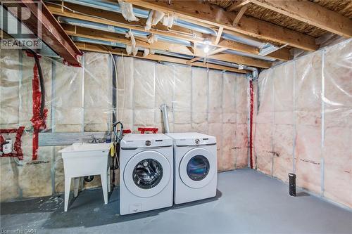 Unfinished basement area featuring exposed ceiling joists, insulated walls, a utility sink, and a painted concrete floor - 226 Maitland Street, Kitchener, ON 