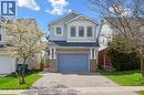 View of front of home featuring a garage, driveway, a shingled roof, stone siding, and brick siding - 47 Mccurdy Road, Guelph, ON 