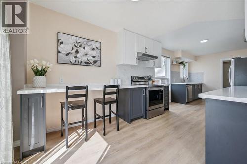 Kitchen featuring appliances with stainless steel finishes, white cabinetry, tasteful backsplash, gray cabinets, and light wood-style flooring - 47 Mccurdy Road, Guelph, ON 