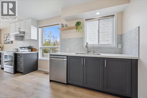 Kitchen with backsplash, open shelves, appliances with stainless steel finishes, gray cabinets, and white cabinets - 47 Mccurdy Road, Guelph, ON 