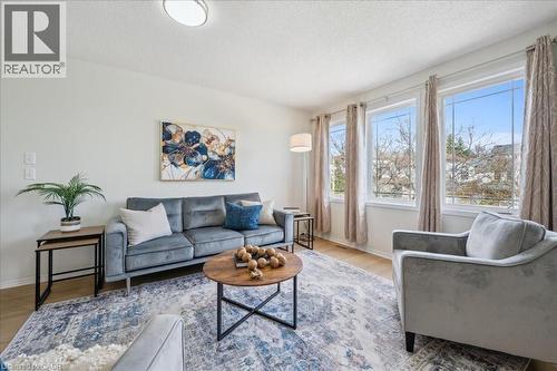 Living area with wood finished floors and a textured ceiling - 47 Mccurdy Road, Guelph, ON 