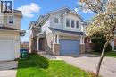 View of front of property with an attached garage, brick siding, asphalt driveway, and a front yard - 47 Mccurdy Road, Guelph, ON 