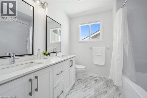 Full bathroom featuring shower / tub combo with curtain and light marble finish floors - 47 Mccurdy Road, Guelph, ON 