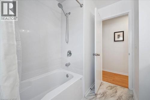 Bathroom featuring shower / bath combination with curtain and baseboards - 47 Mccurdy Road, Guelph, ON 