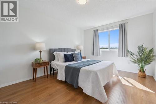Bedroom featuring wood finished floors and a textured ceiling - 47 Mccurdy Road, Guelph, ON 