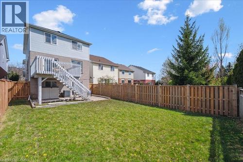Back of house with a fenced backyard, a patio area, brick siding, stairs, and a residential view - 47 Mccurdy Road, Guelph, ON 
