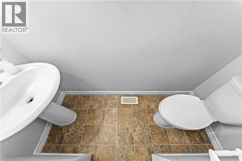 Pedestal sink with white basin, white toilet, and tile flooring - 245 Red Clover Court, Kitchener, ON 