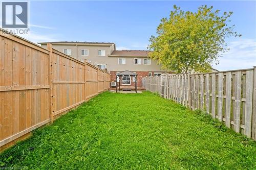Fenced backyard featuring a manicured lawn and a wooden deck with a gazebo - 245 Red Clover Court, Kitchener, ON 