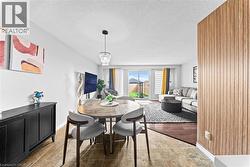 Open living space featuring wood-finish flooring, light-toned wall paneling, and sliding glass doors - 