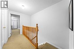 Neutral wall finishes complement the light wood-tone railing and carpeted flooring - 