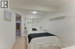 White walls featuring a floating shelf and wood-finish flooring - 