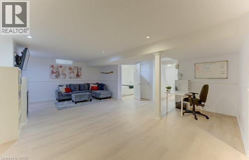 Spacious room featuring light wood-finish flooring, recessed lighting, and white paneled walls - 88 Decaro Crescent, Cambridge, ON 