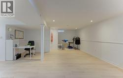 Recessed lighting illuminating the large open-concept space featuring wood-finish flooring and wainscoting - 