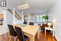 Hardwood flooring, decorative columns, a contemporary chandelier, and a white-framed window - 