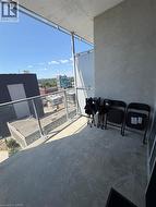 Balcony featuring a concrete floor, glass railing, and urban landscape - 