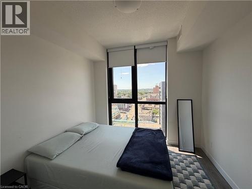 Floor-to-ceiling window with roller shades, recessed ceiling light, wood-finish flooring, and white painted walls - 60 Frederick Street Unit# 1213, Kitchener, ON 