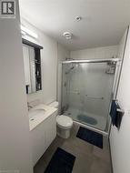 Bathroom featuring a shower enclosure with glass sliding doors, a white vanity with an integrated sink, and a mirrored medicine cabinet - 